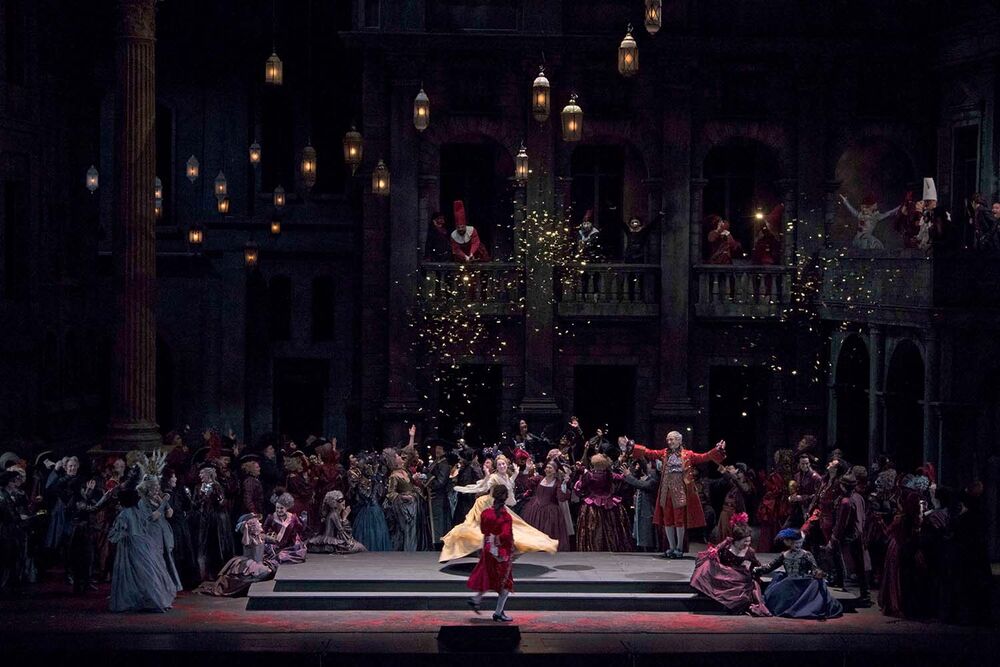 A scene from Romeo et Juliette shows people dancing on a stage. Lanterns hang from the ceiling.