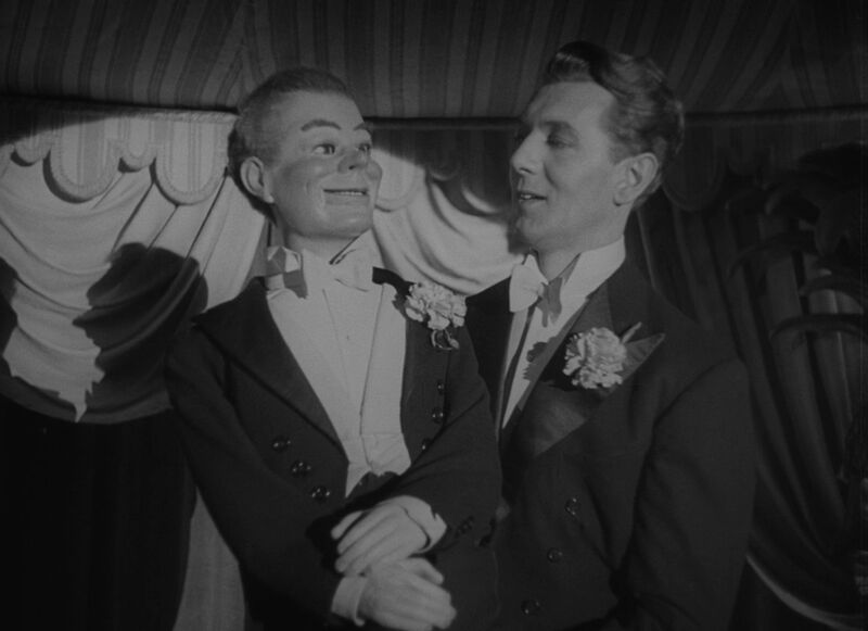 Man on stage holding a Ventriloquist dummy