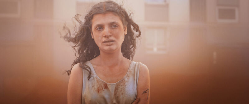 Creepy photo of girl in a dusty street, her hair blowing, an A carved on her arm.