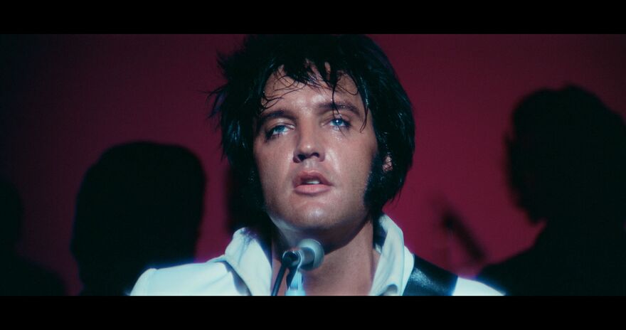 A close-up on Elvis's face as he performs on stage