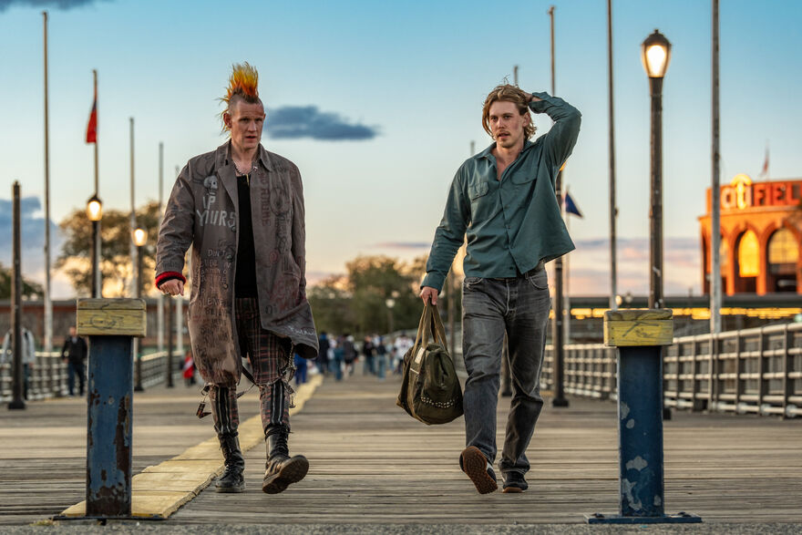 Matt Smith and Austin Butler walk along a street with a mysterious bag