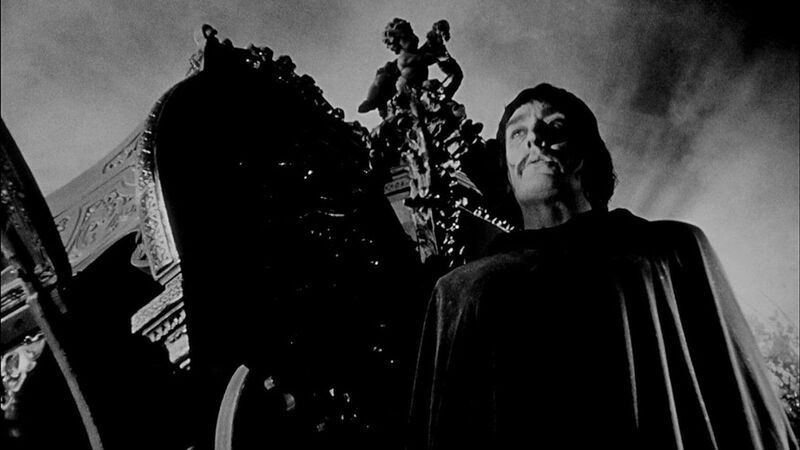 Black and white image of a man infront of an ornate building / carriage