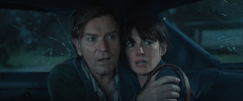 A man and woman embrace in fear