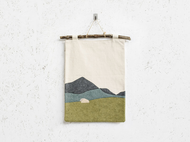 Fabric wall handing featuring a view of mountails and a sheep in a field