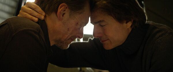 Two men sit with their heads together.
