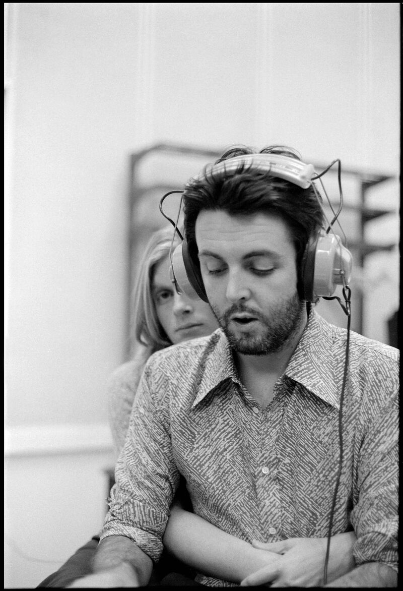 Paul McCartney and Linda McCartney photographed together while Paul wears headphones and records music