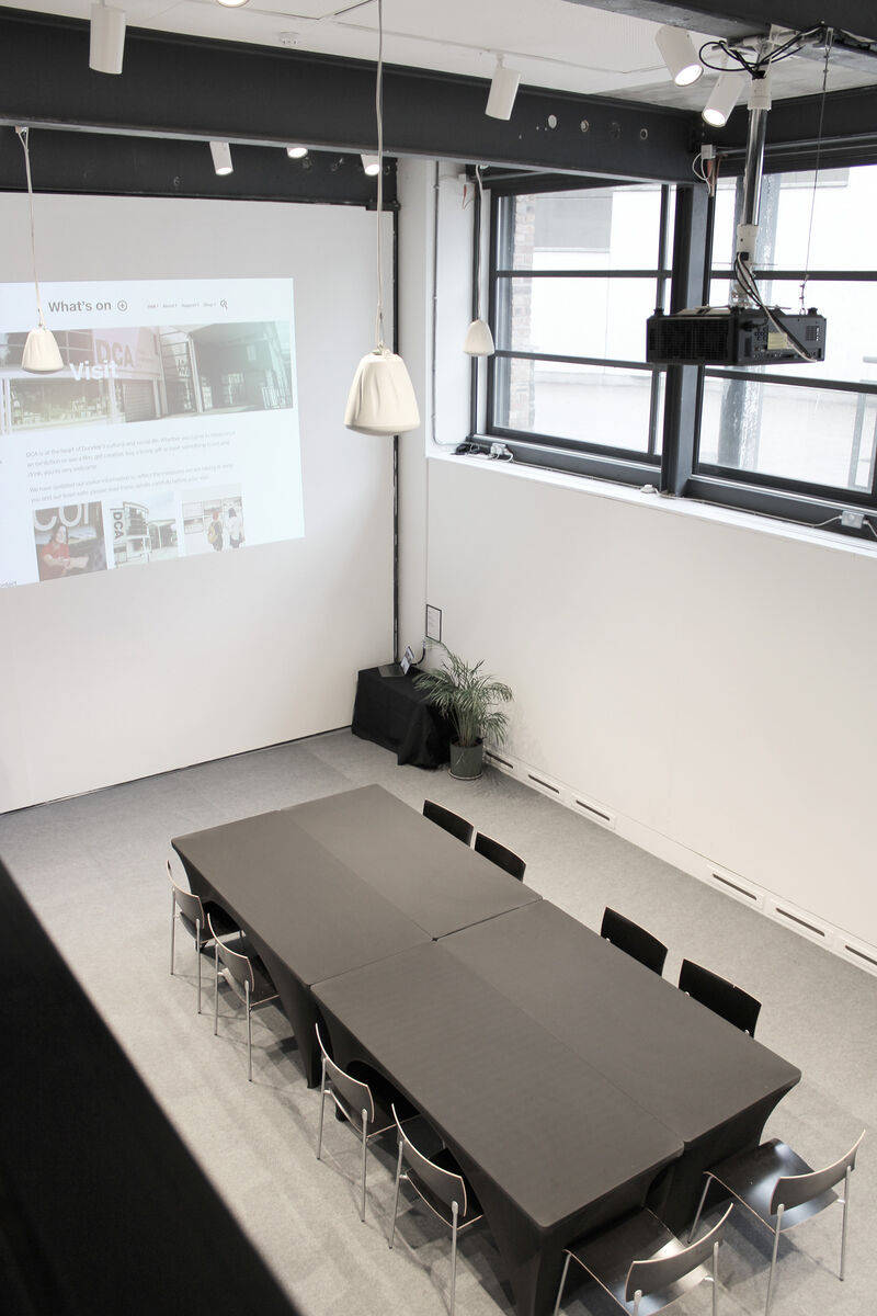 The Centrespace is set up with a table for 10 people. The projector screen shows a website.