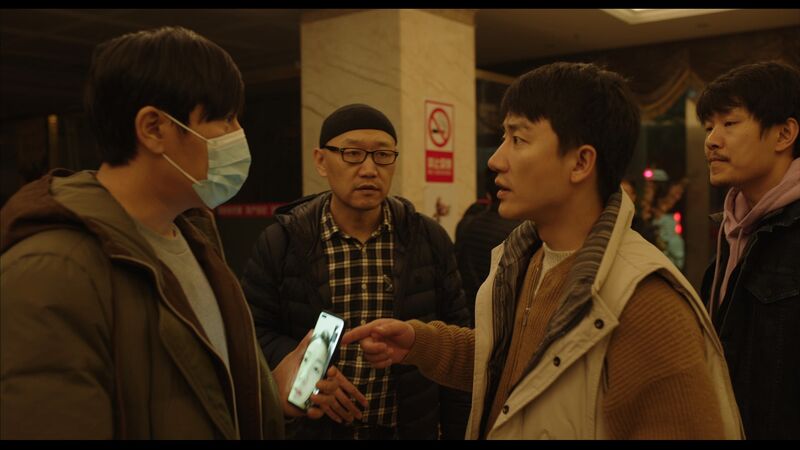 A man talks to another man wearing a covid mask.