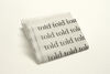 Pile of paper tissues with text reading 'told' printed on the top tissue