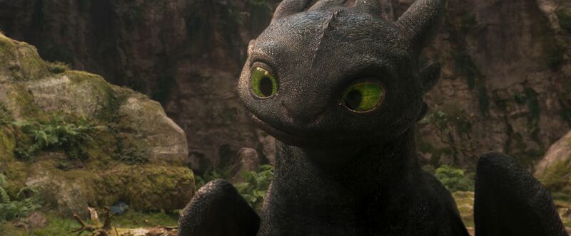 A black dragon with big green eyes and cute expression.