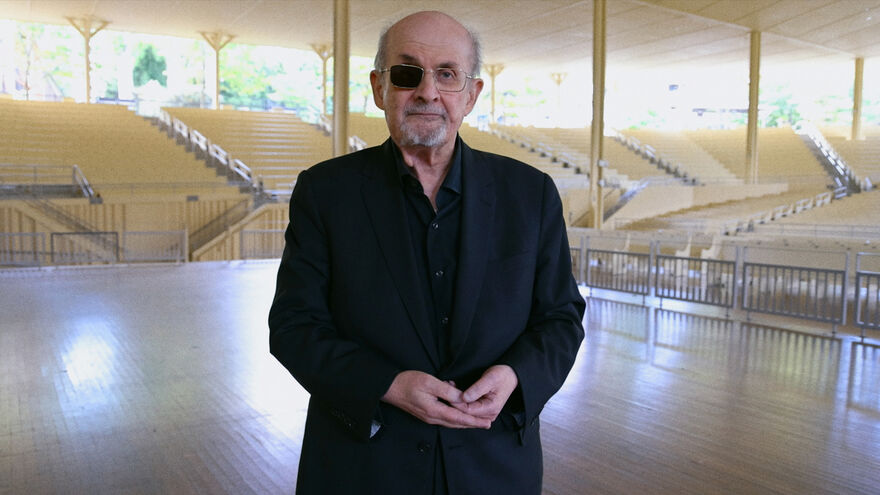 Author Salman Rushdie stands in an empty venue