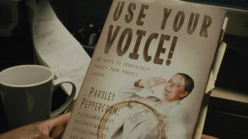 a book cover with the title Use Your Voice and a person smiling and holding their hand to their mouth - a coffee stain is visible on the book and cup in the background