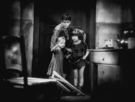 a black and white image of three children cowering in the corner 