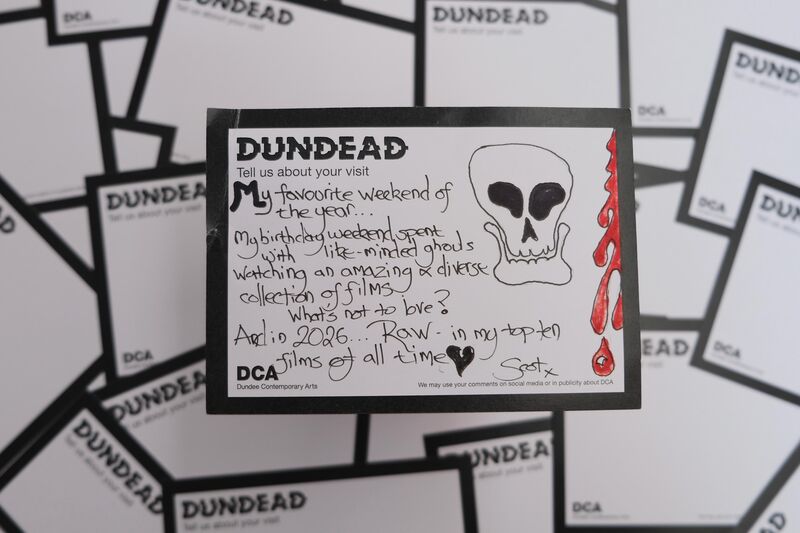 Handwritten Dundead comment card: ‘My favourite weekend of the year… My birthday weekend spent with like-minded ghouls watching an amazing and diverse collection of films - what’s not to love? And in 2026…Raw…in my top ten films of all time. Scot’ with drawing of a skull and blood drips
