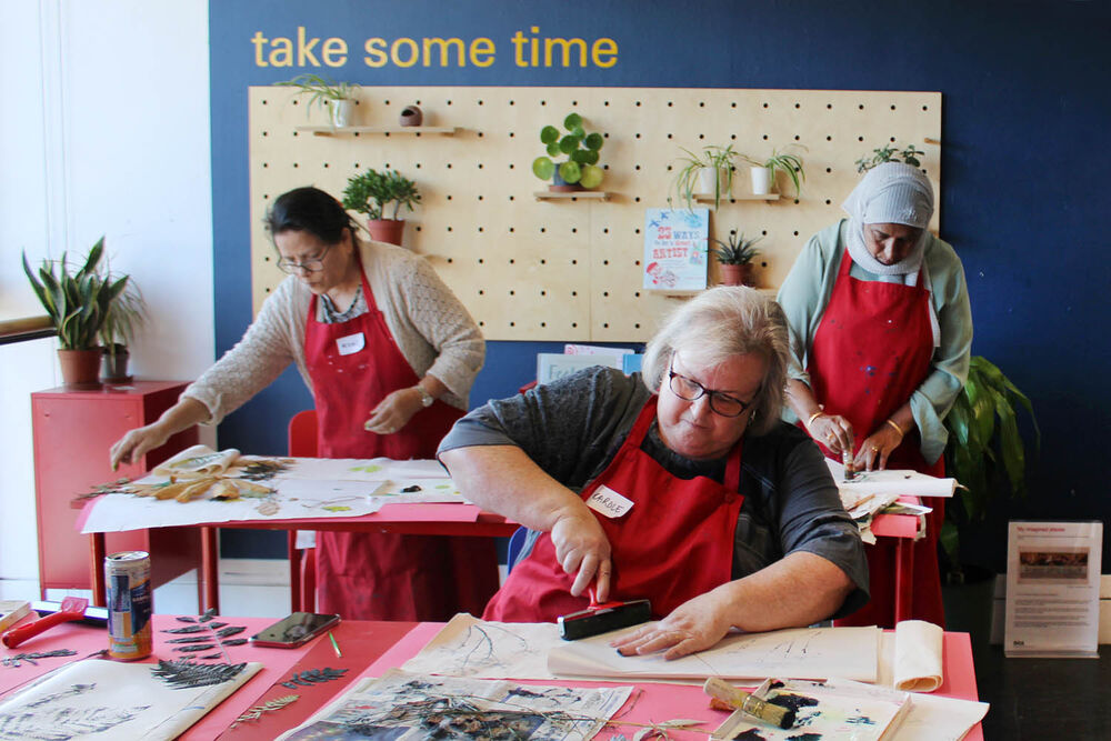 People wearing red aprons take part in craft activities at our Craft Sunday event.