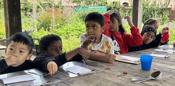 Group of children sitting at a table in The Maxwell Centre's community garden