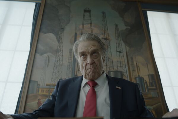 The President of the US sits looking unhappy in front of. painting of oil wells