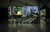 A photograph of a two channel film. The image shows a train on a track. The films reflects off the gallery floor. 