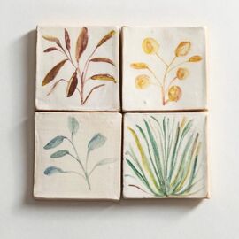 Four tiles hand painted with plant illustrations