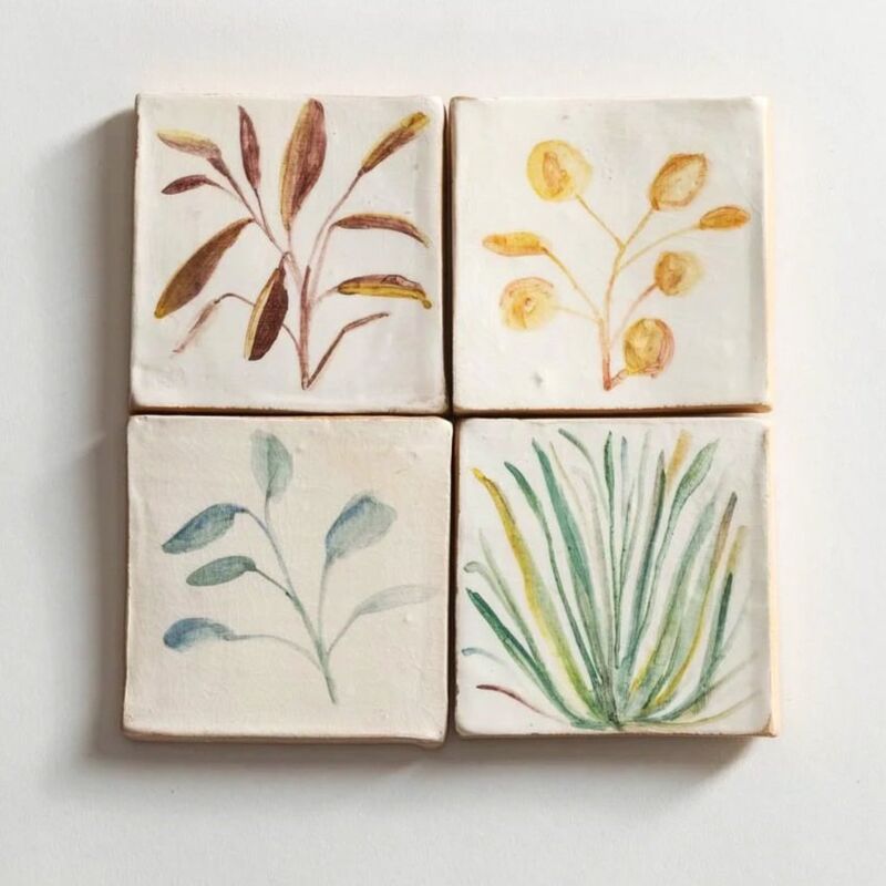 Four tiles hand painted with plant illustrations