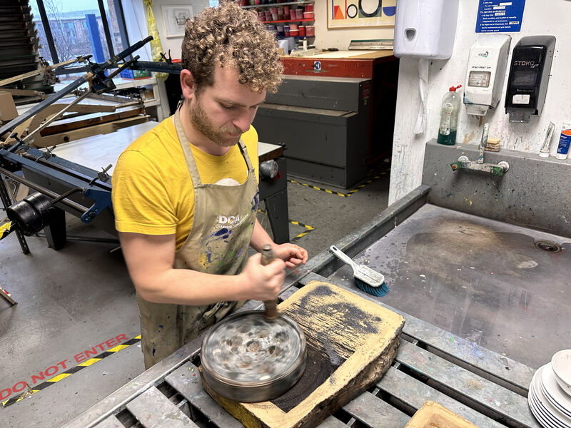 Tutor preparing a stone for stone lithography