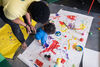 Parent helping a baby to paint on a large white sheet of paper