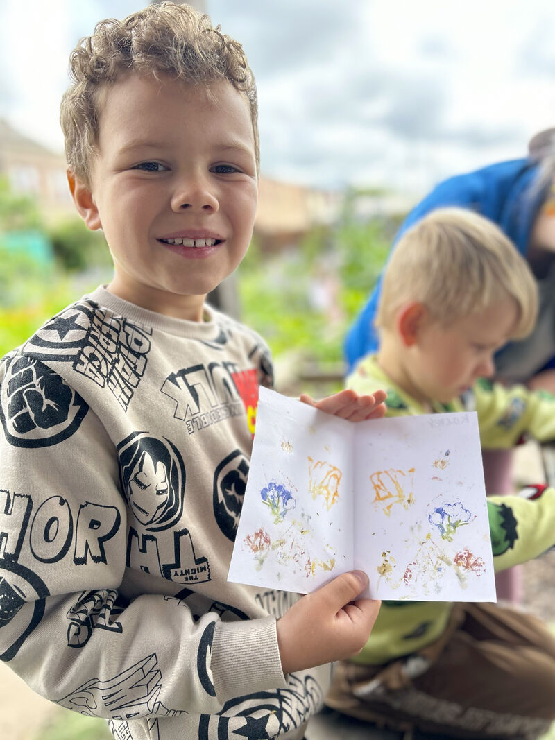 Child showing off his zine featuring flower prints