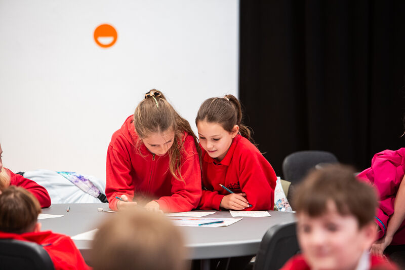 Two girls working together at a table in DCA.