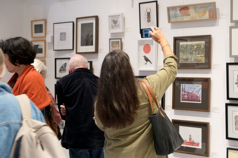 Person taking a photo of framed prints