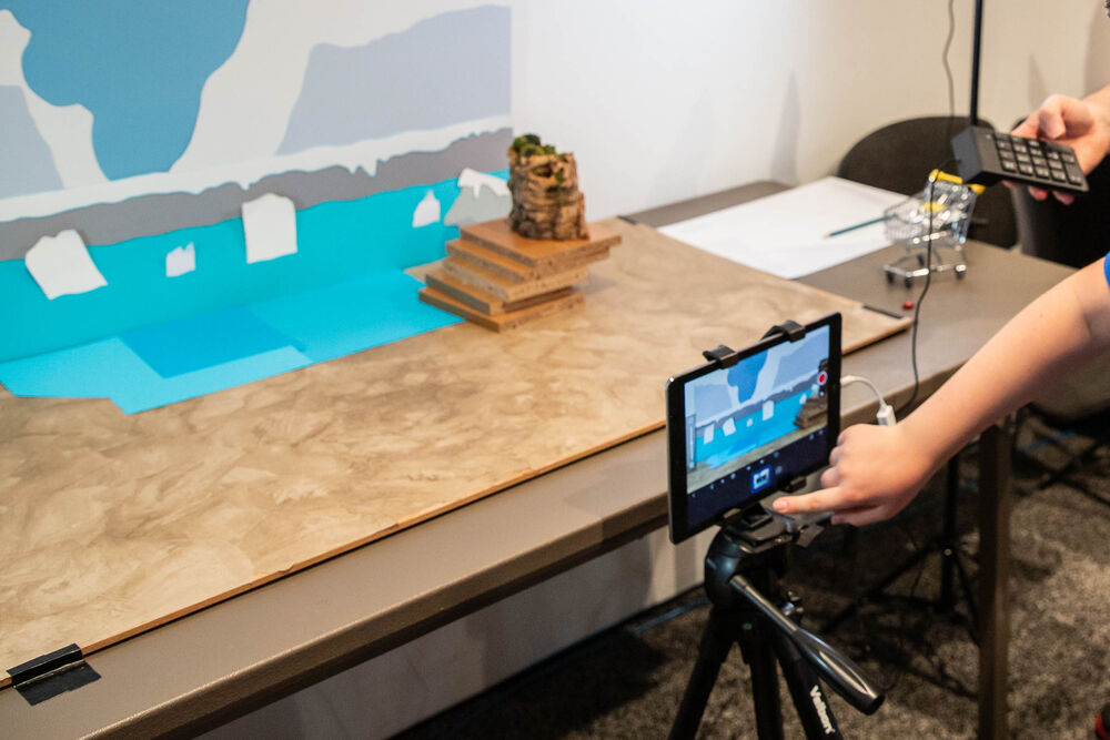 Person adjusting an iPad while filming a stop motion scene