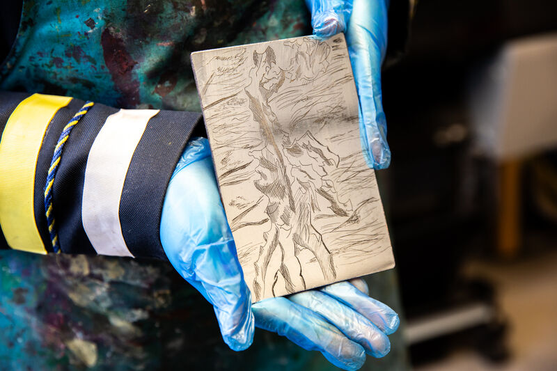Morgan Academy pupil showing an etching plate with image of a landscape