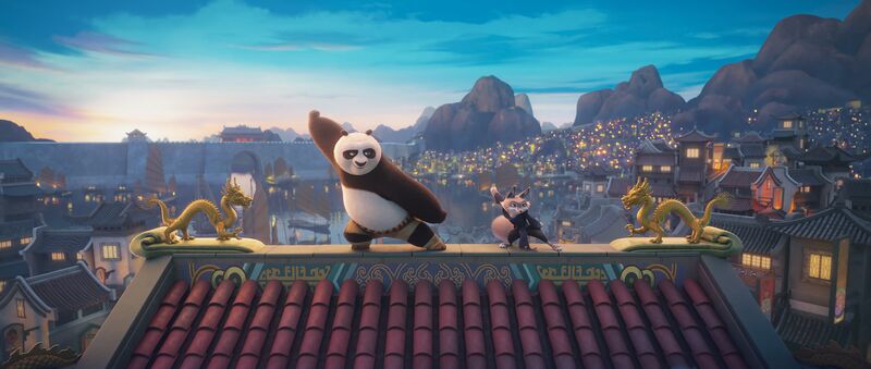 An animated panda and a fox strike a kung fu pose on top of a roof.