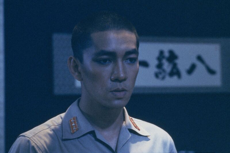 A Japanese man stands in military uniform