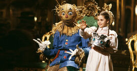 Dorothy waves as she crowns the Scarecrow