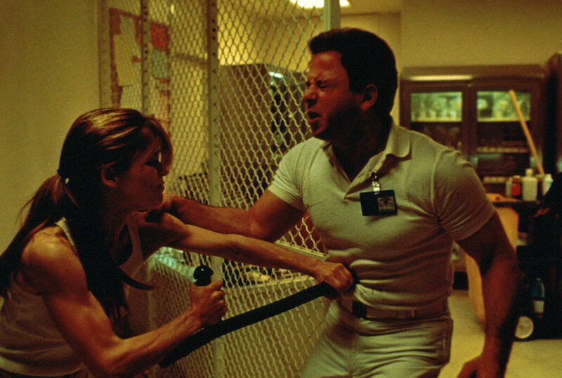 A woman rams a baton into the stomach of a security guard