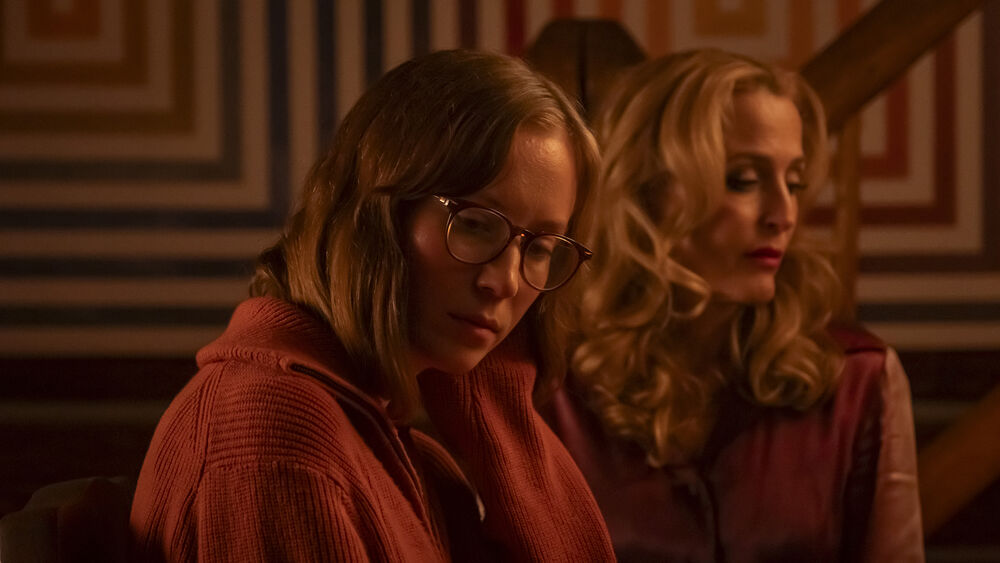 Two women bathed in an orange light