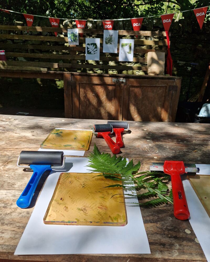 Outdoor table set up for gelli printing with DCA bunting in the background