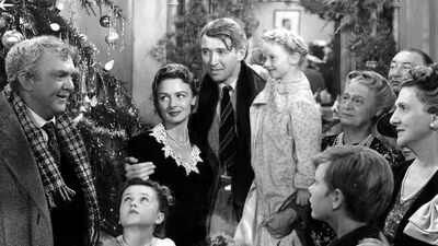 Black and white film still of a happy family around a Christmas tree from It's a Wonderful Life