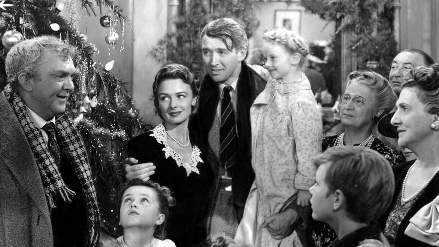 Black and white film still of a happy family around a Christmas tree from It's a Wonderful Life