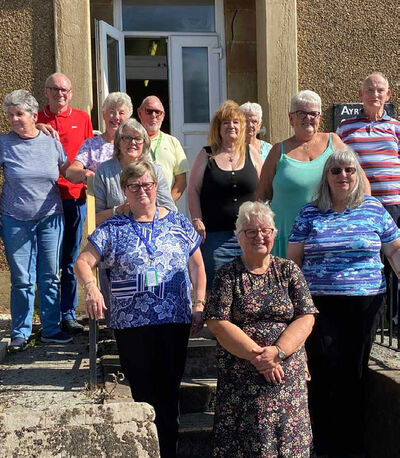 A group from Ayrshire Community for the Deaf stand outside in the sun
