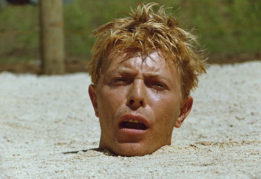 A man is buried up to his head in sand