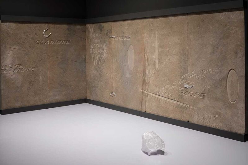 the corner of an exhibition looking like a cave with carvings in the wood