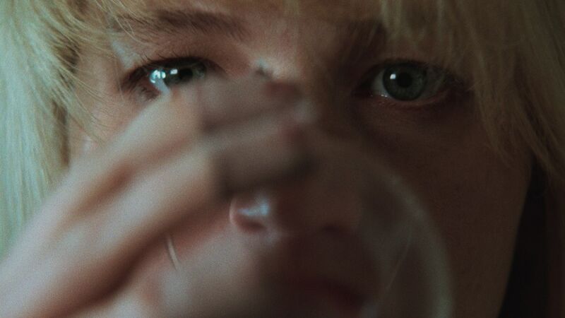 A close up of a blonde woman drinking from a glass