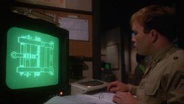 A man looks at a computer screen with a green map on it