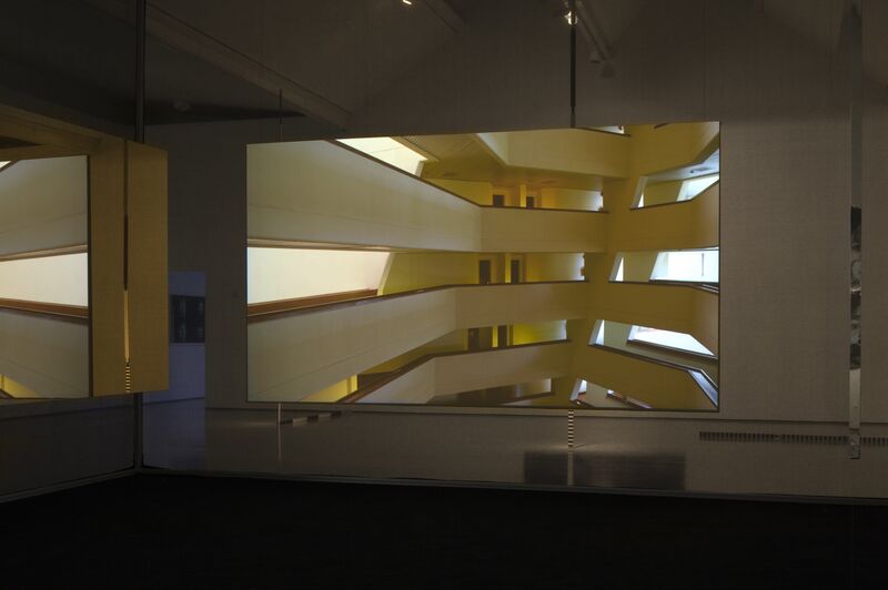 A photograph from Jane & Louise Wilson's exhibition. Shows a white building with an internal balcony wrapping around.