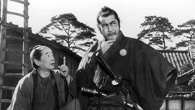 Sanjuro the samurai hands next to a shorter man.