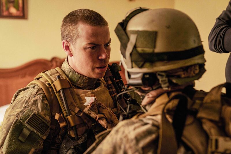 One young soldier looks at another.