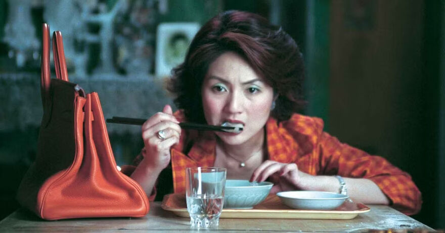Woman eating a dumpling with chopsticks