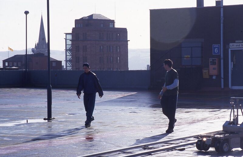 From Roderick Buchanan's exhibition in DCA Galleries. A film still of two people walking in a car park in Dundee.