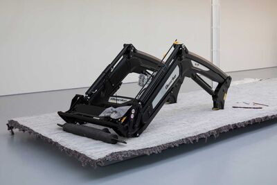 some large farm equipment sitting in a gallery space 